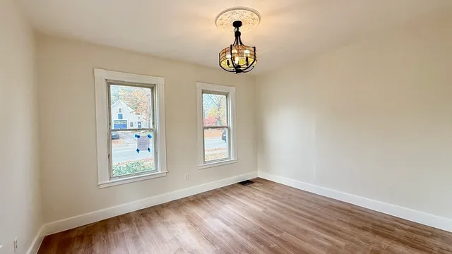 an empty room with window and wooden floor