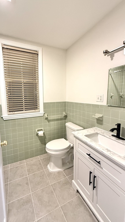 225 Pleasant Street, Unit 1 Weymouth, MA 02190 - Photo 7 of 10 a bathroom with a granite countertop toilet a sink and a bathtub