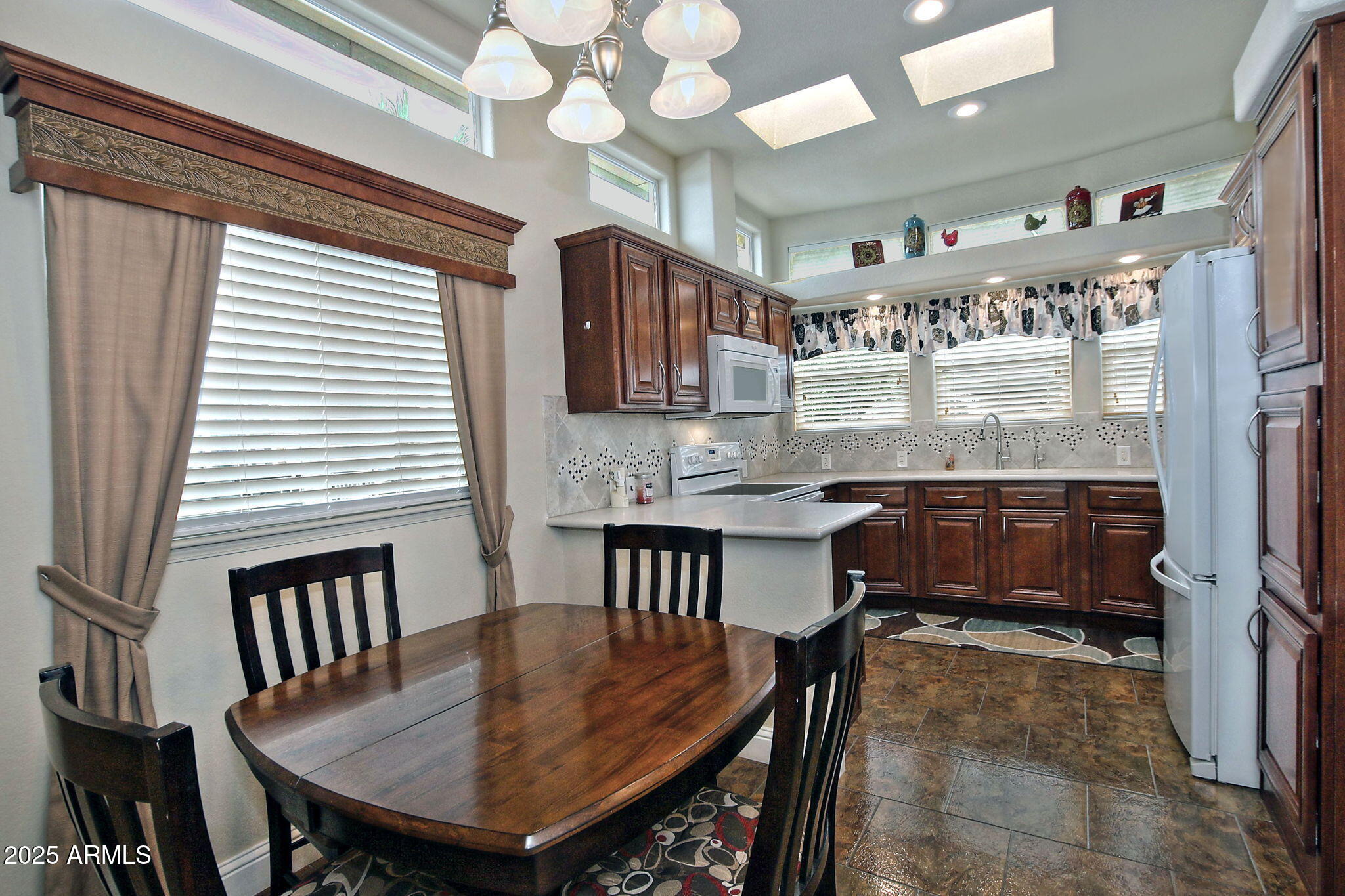 111 South Greenfield Road, Unit 462 Mesa, AZ 85206 - Photo 11 of 34 a kitchen with a table chairs stove and cabinets