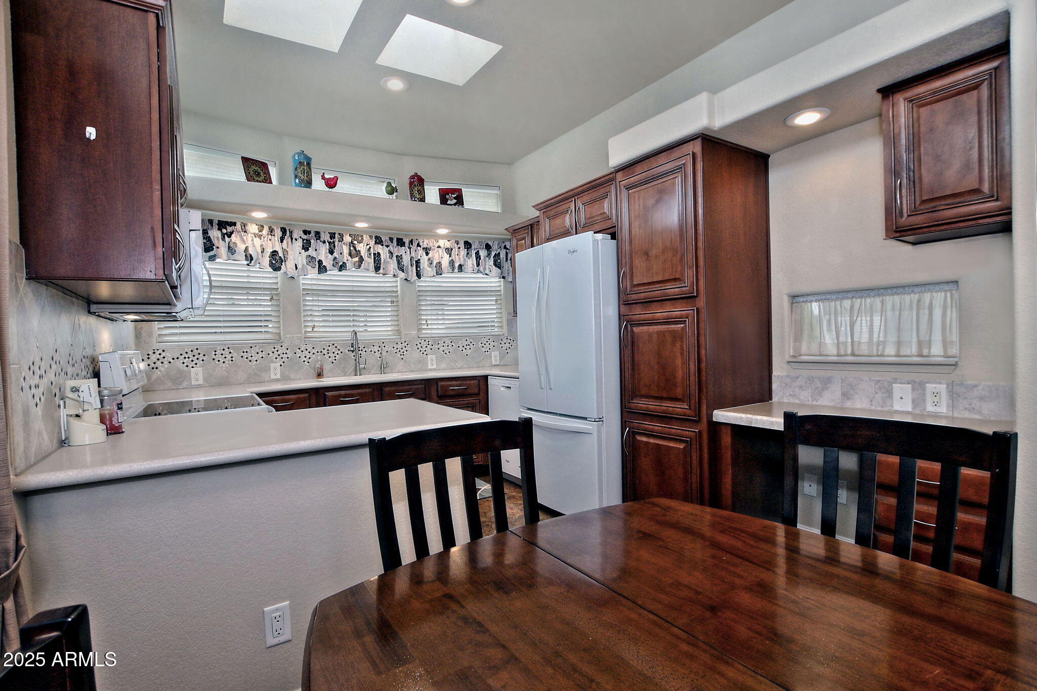 111 South Greenfield Road, Unit 462 Mesa, AZ 85206 - Photo 12 of 34 a kitchen with stainless steel appliances granite countertop a refrigerator a stove and wooden cabinets with wooden floor