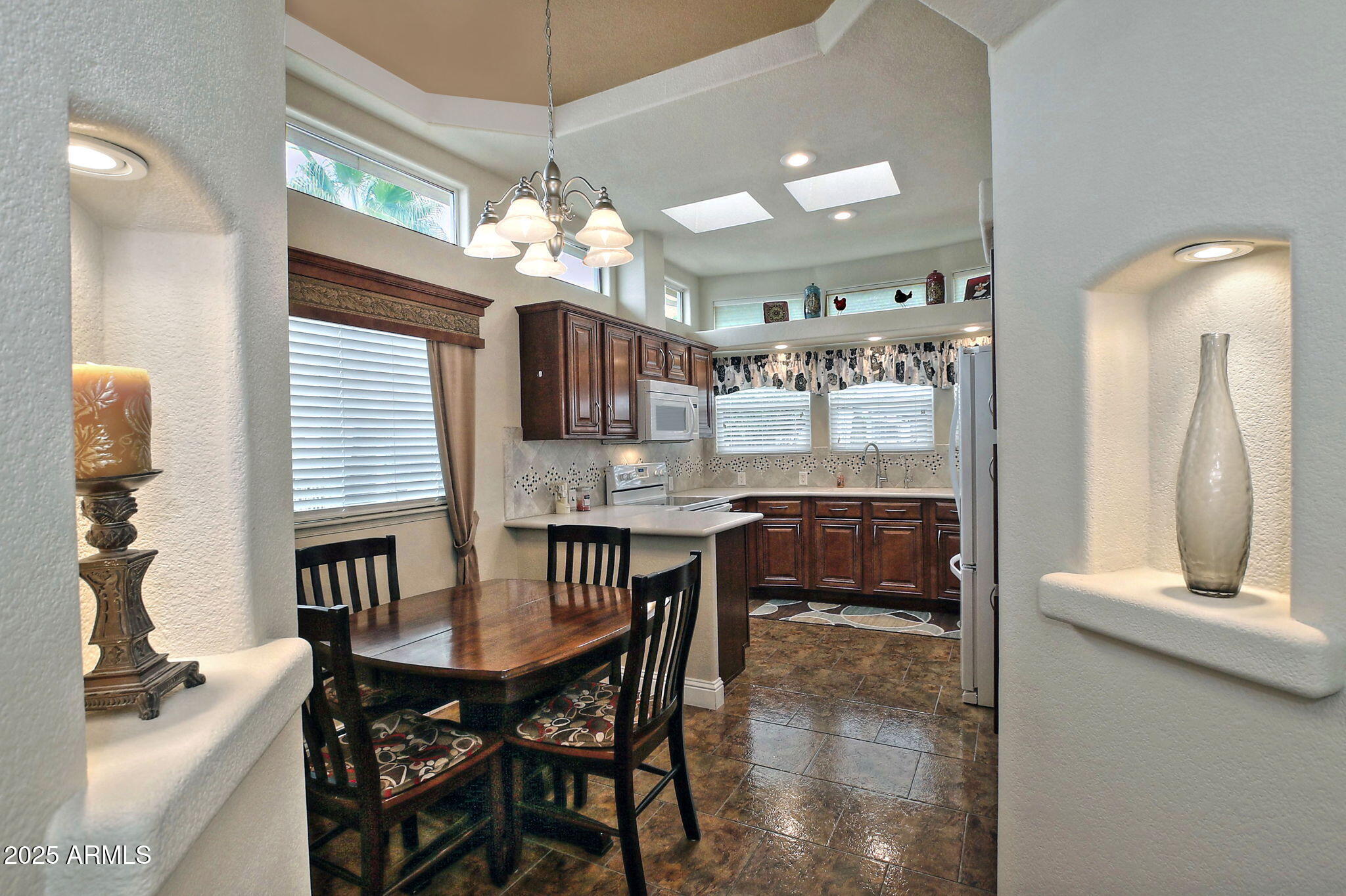 111 South Greenfield Road, Unit 462 Mesa, AZ 85206 - Photo 2 of 34 an open kitchen with dining table and chandelier