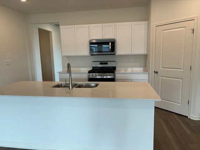 a kitchen with granite countertop a stove and a microwave