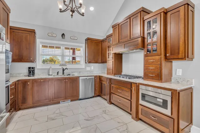 a kitchen with stainless steel appliances granite countertop a sink and cabinets