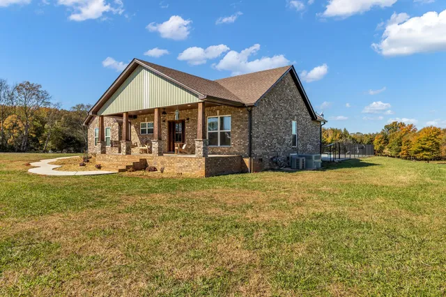 a front view of house with yard and trees in the background