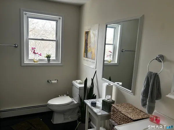 a bathroom with a toilet a sink and a window