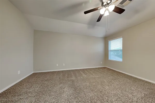 an empty room with a window and a fan