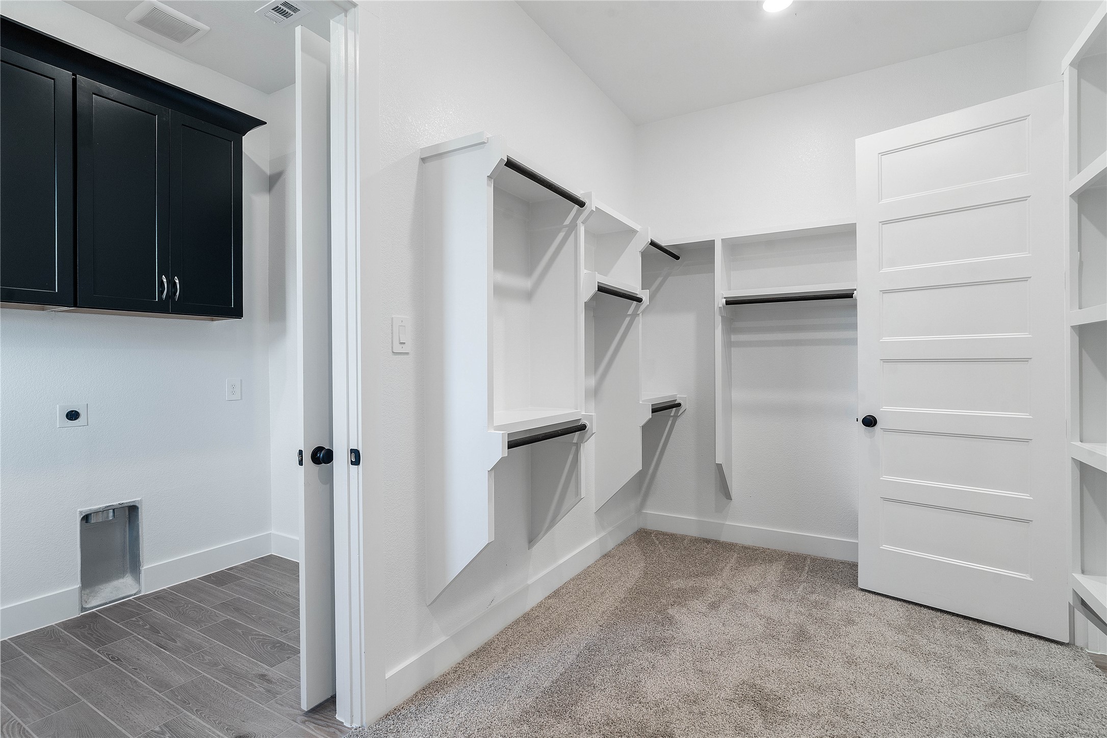 2114 Rowl Street Montgomery, TX 77316 - Photo 38 of 50 Experience the height of functional luxury in this massive primary walk-in closet. Designed with a custom built-in organization system, it offers tiered hanging rods and integrated shelving for a boutique-like wardrobe display. For effortless lifestyle flow, this closet provides direct access to the laundry room.
