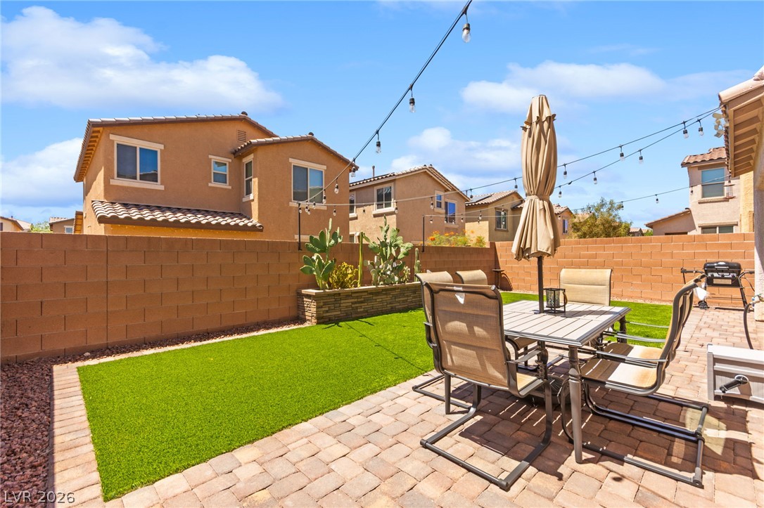 6435 Point Isabel Way Las Vegas, NV 89122 - Photo 49 of 57 A private, low-maintenance yard offers paved patio seating and a vibrant faux-grass lawn.