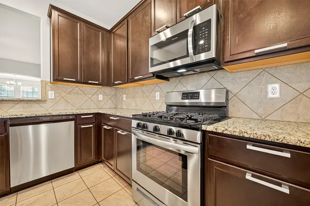 a kitchen with stainless steel appliances granite countertop a stove and a microwave