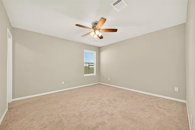 an empty room with windows and fan