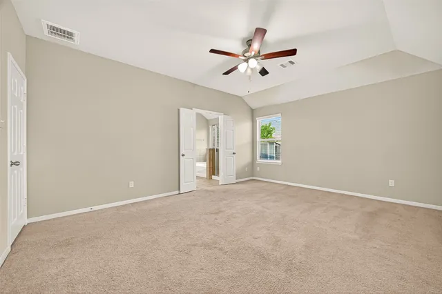 a view of an empty room with a ceiling fan