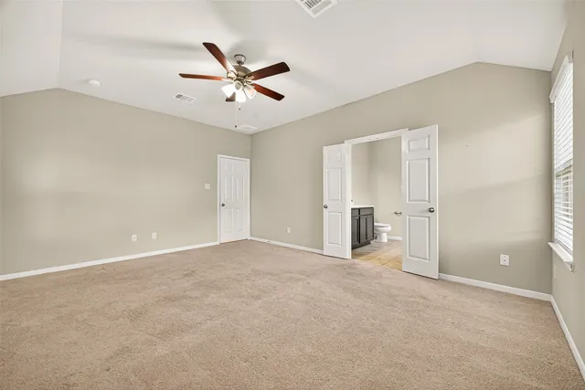 an empty room with closet and fan