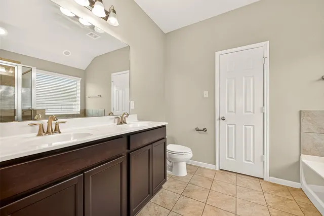 a bathroom with a double vanity sink a toilet and a mirror