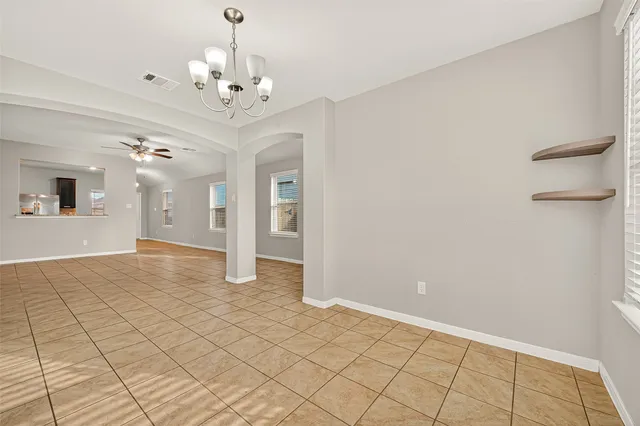 wooden floor in an empty room with a chandelier