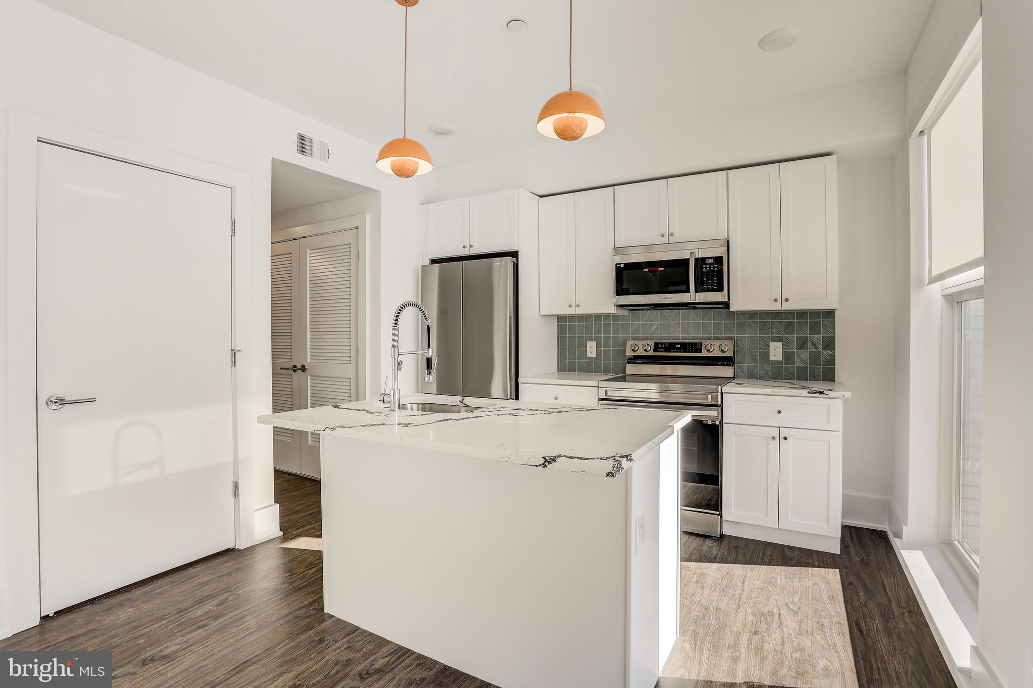 5959-63 Ridge Avenue, Unit 1BED/1BATH Philadelphia, PA 19128 - Photo 1 of 32 a kitchen with stainless steel appliances granite countertop a refrigerator a stove top oven a sink and dishwasher