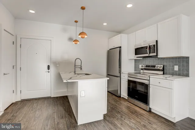 a kitchen with a sink stainless steel appliances and white cabinets