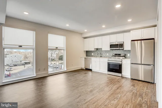 a kitchen with stainless steel appliances a refrigerator sink and microwave