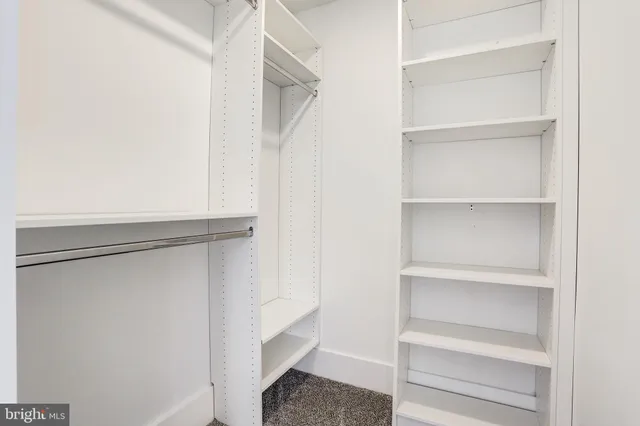 a view of walk in closet with empty racks