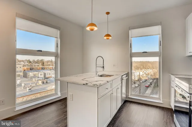 a kitchen with a sink window and wooden floor