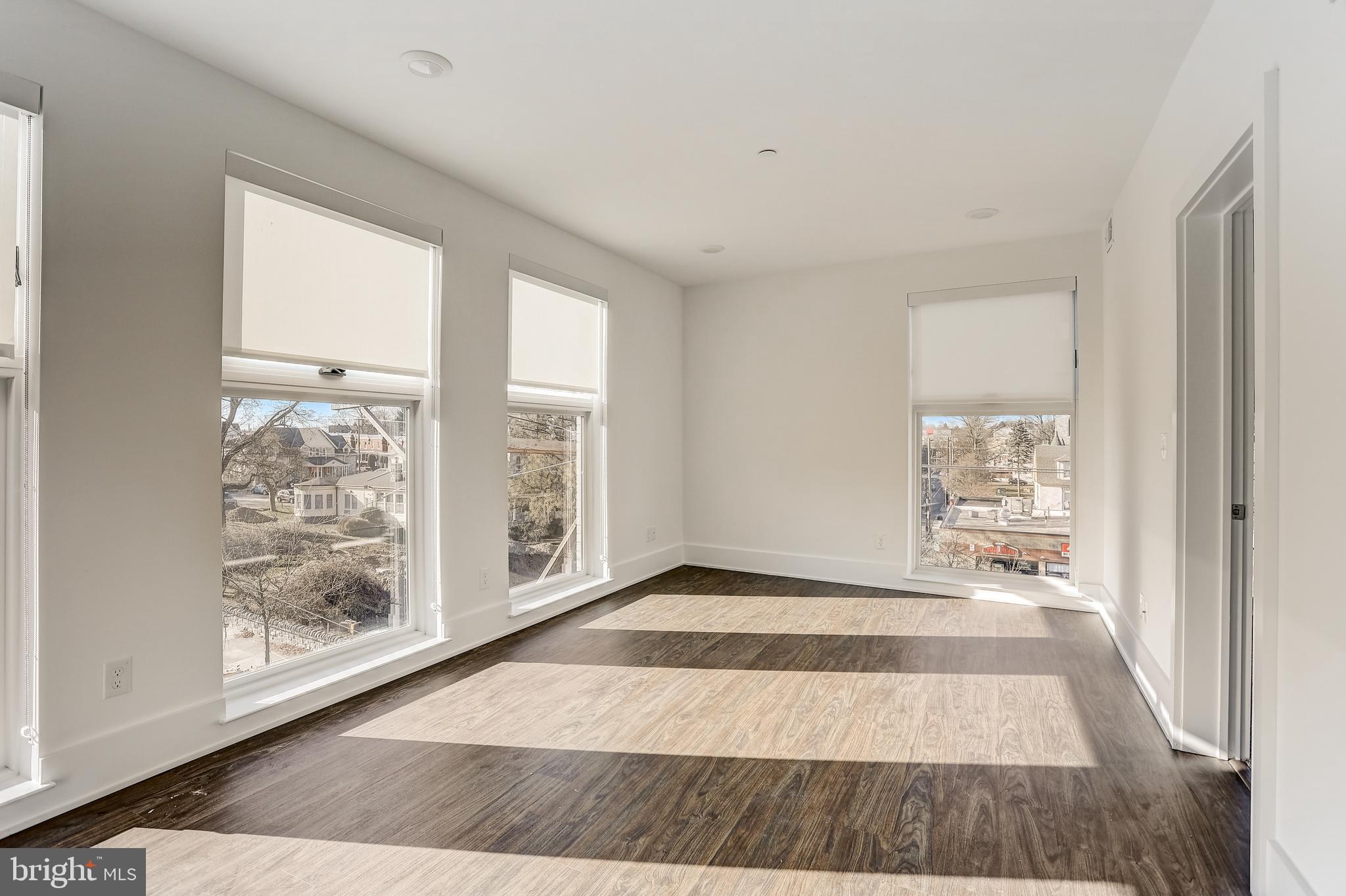 5959-63 Ridge Avenue, Unit 1BED/1BATH Philadelphia, PA 19128 - Photo 3 of 32 a view of an empty room with window and wooden floor