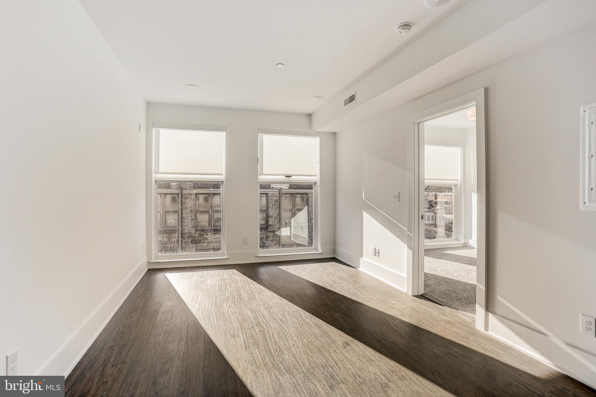 5959-63 Ridge Avenue, Unit 1BED/1BATH Philadelphia, PA 19128 - Photo 9 of 32 a view of an empty room with wooden floor and a window