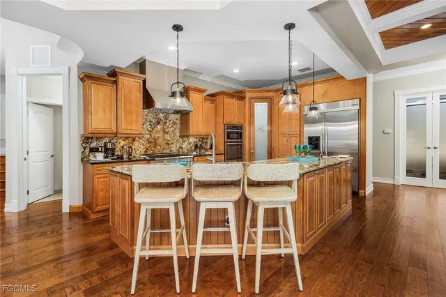 a dining room with wooden floor and large windows