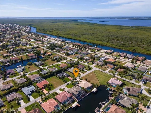 an aerial view of ocean and residential houses with outdoor space