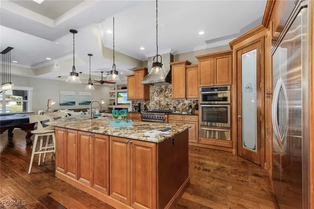 a kitchen with stainless steel appliances granite countertop a sink a stove and a refrigerator