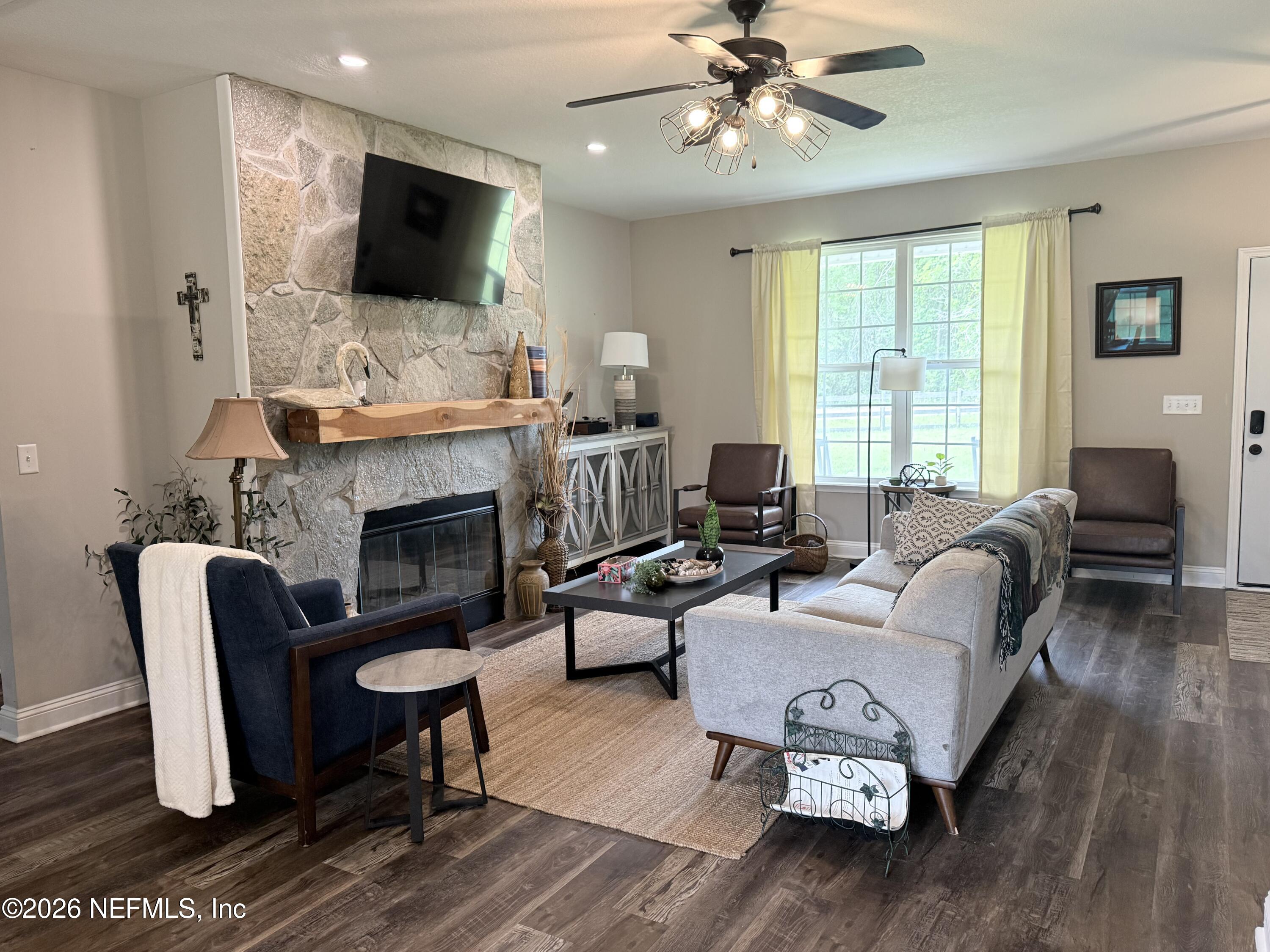 204 Comer Road Palatka, FL 32177 - Photo 6 of 15 a living room with furniture a flat screen tv and a fireplace