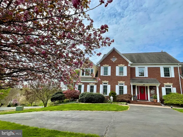 a front view of a house with a yard and potted plants