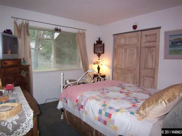 20710 Cooke Drive Reno, NV 89521 - Photo 9 of 13 a bedroom with a bed and wooden floor