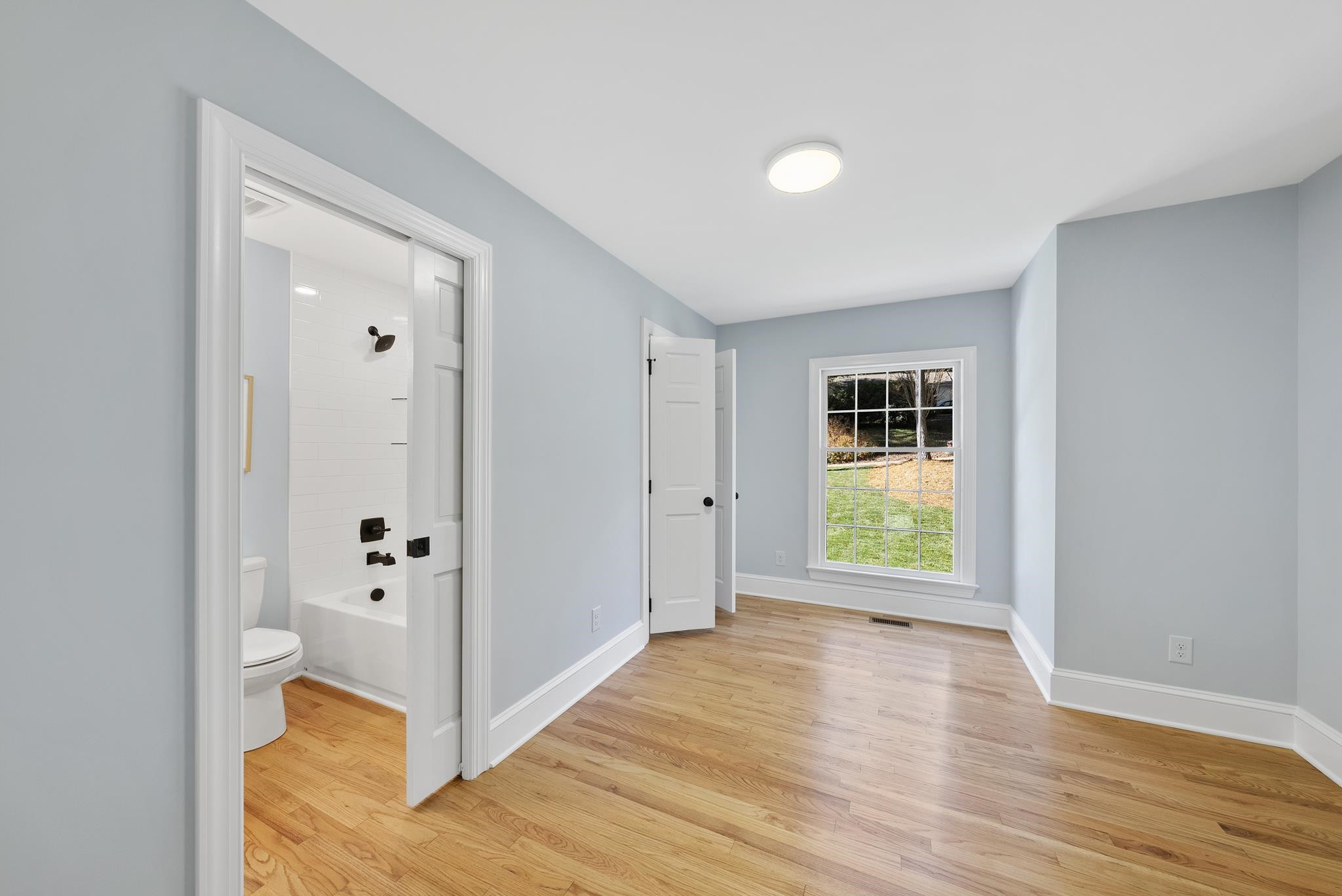 6908 Fernhill Lane Raleigh, NC 27612 - Photo 14 of 24 a view of an empty room with wooden floor and a window