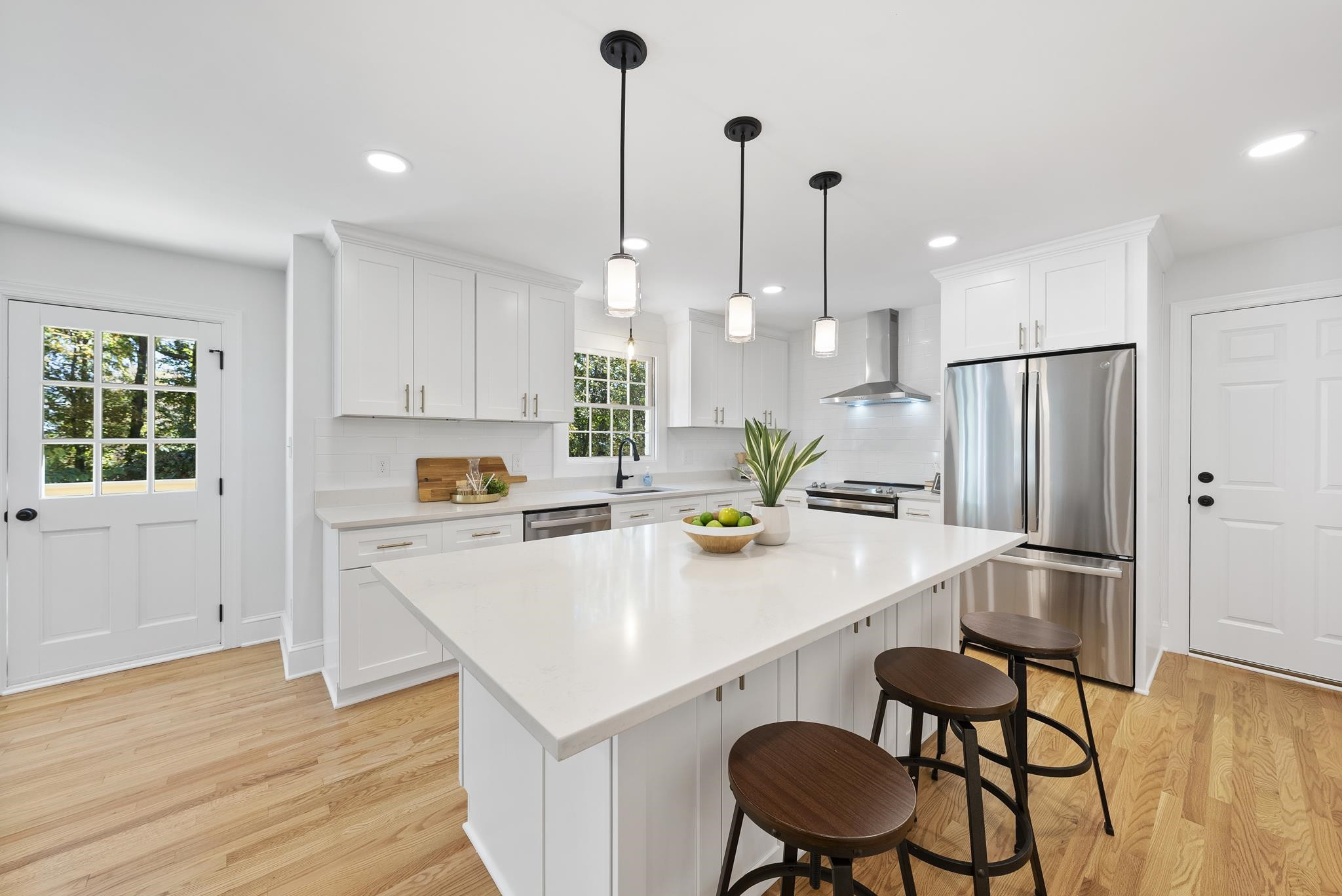 6908 Fernhill Lane Raleigh, NC 27612 - Photo 7 of 24 a kitchen with a refrigerator a stove a sink and white cabinets with wooden floor