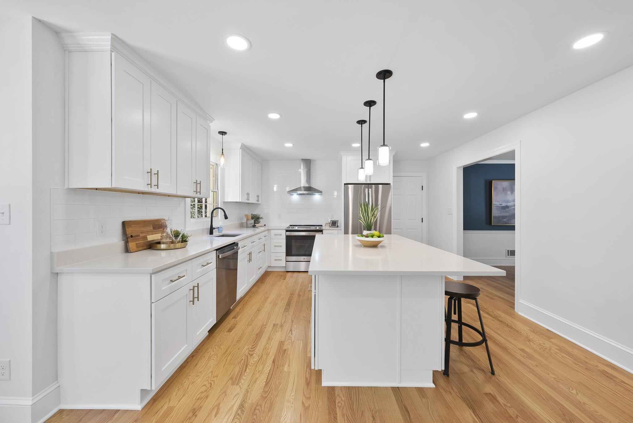 6908 Fernhill Lane Raleigh, NC 27612 - Photo 8 of 24 a large kitchen with kitchen island a stove a sink a center island and wooden floor