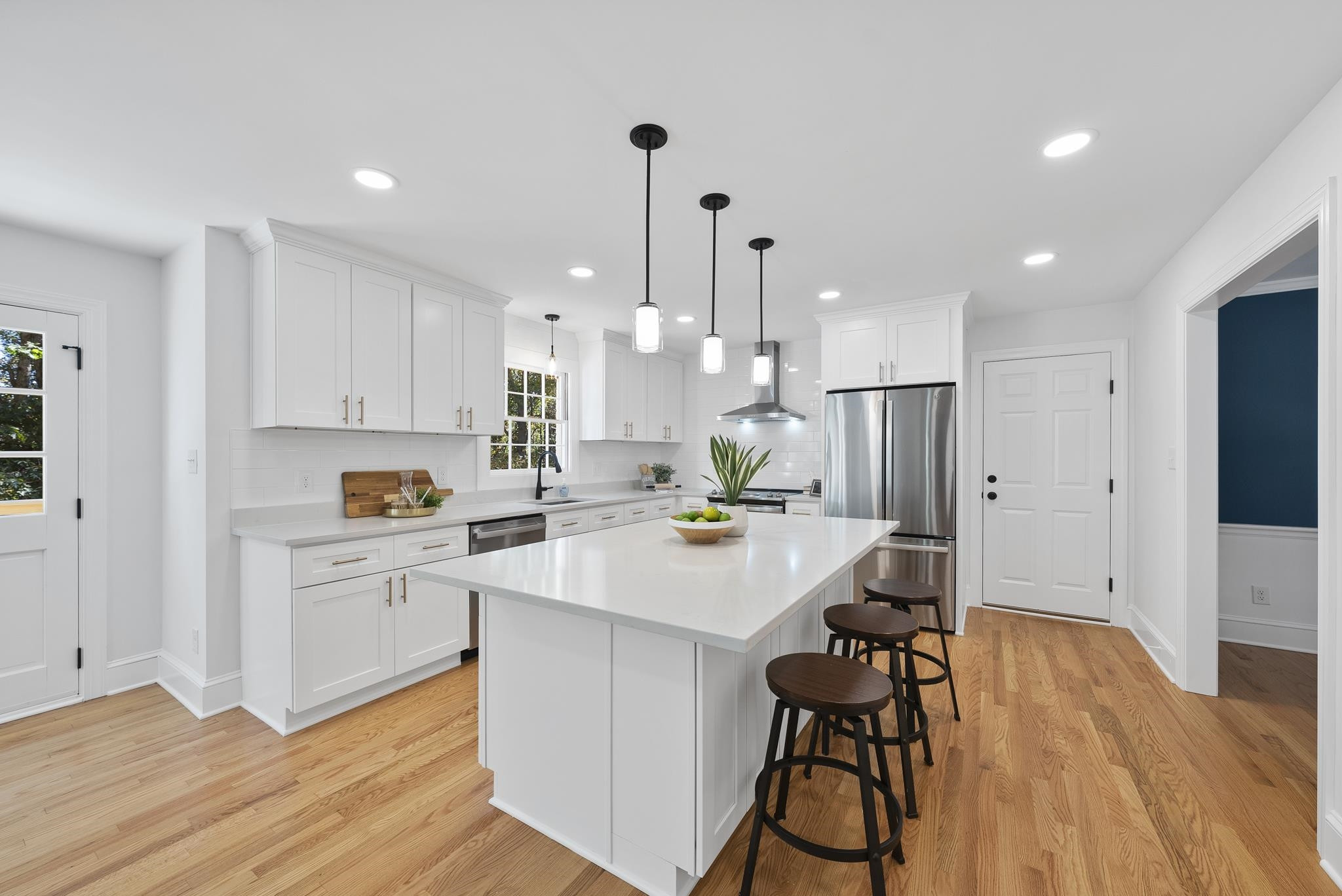 6908 Fernhill Lane Raleigh, NC 27612 - Photo 9 of 24 a kitchen with stainless steel appliances kitchen island a refrigerator and a wooden floor