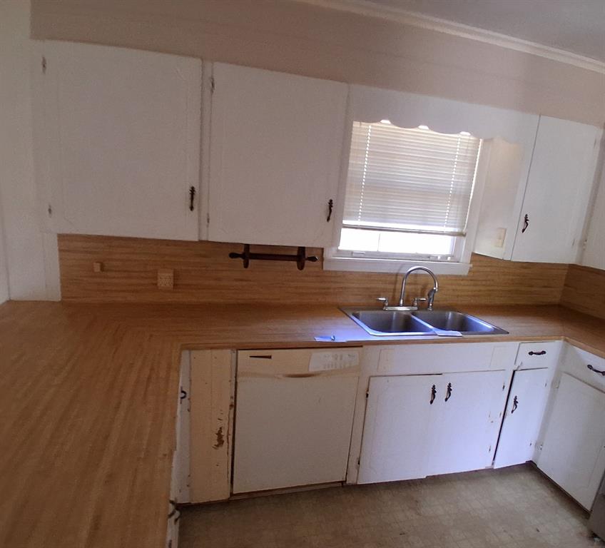 910 Success Street Gilmer, TX 75644 - Photo 11 of 20 a kitchen with a sink a stove and cabinets