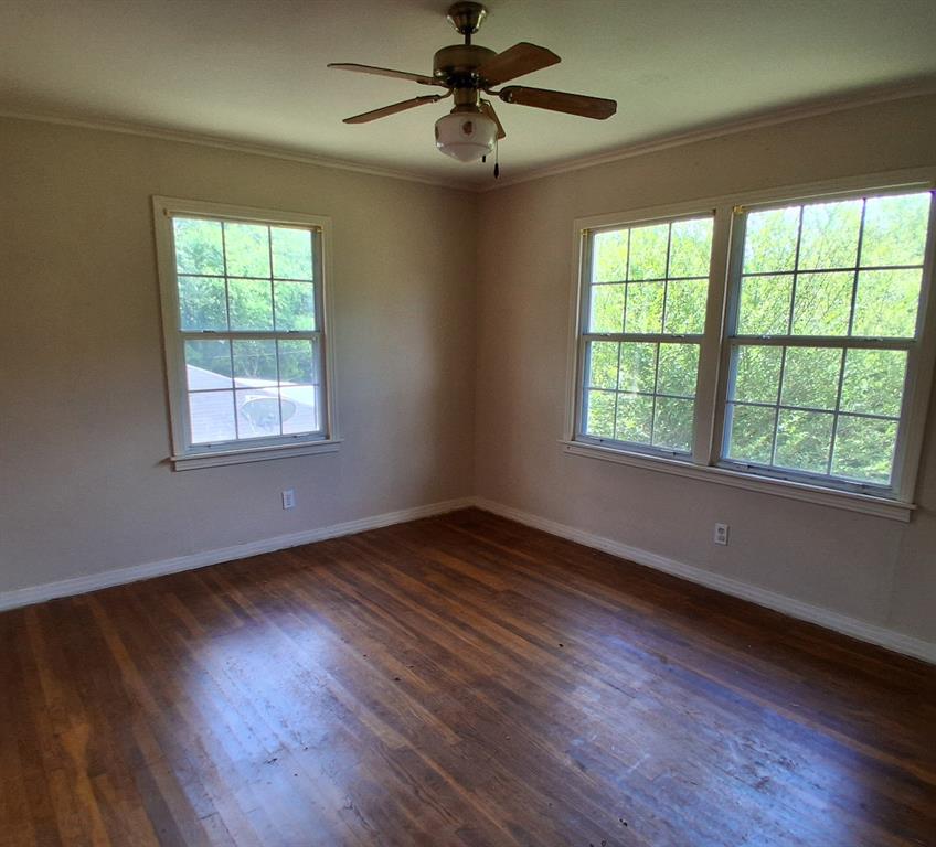910 Success Street Gilmer, TX 75644 - Photo 12 of 20 a view of an empty room with wooden floor and a window