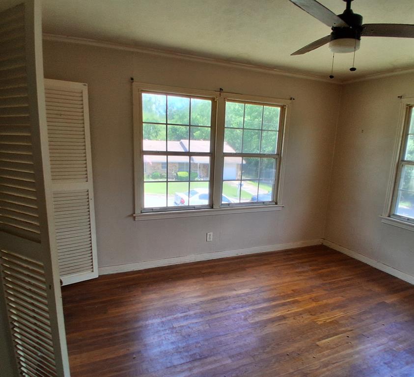 910 Success Street Gilmer, TX 75644 - Photo 14 of 20 an empty room with wooden floor and windows