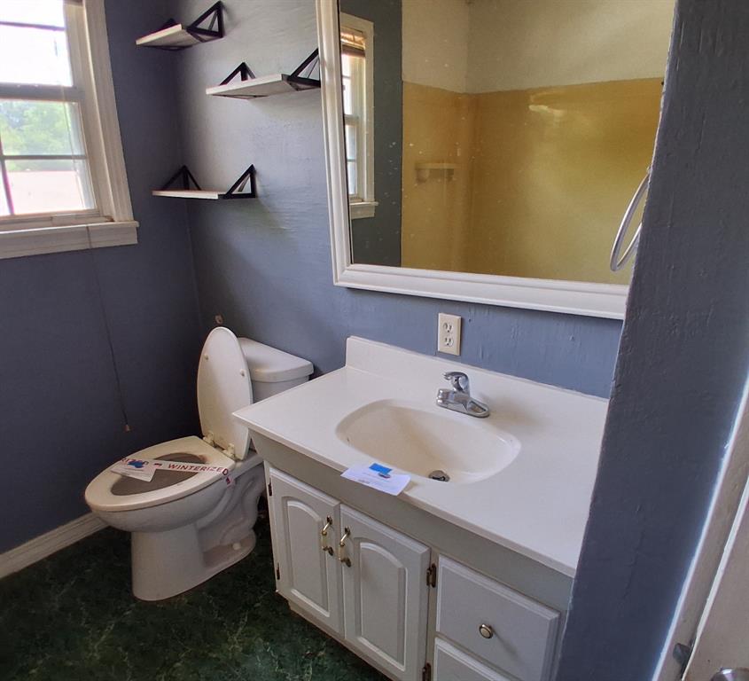 910 Success Street Gilmer, TX 75644 - Photo 16 of 20 a bathroom with a sink a toilet and mirror