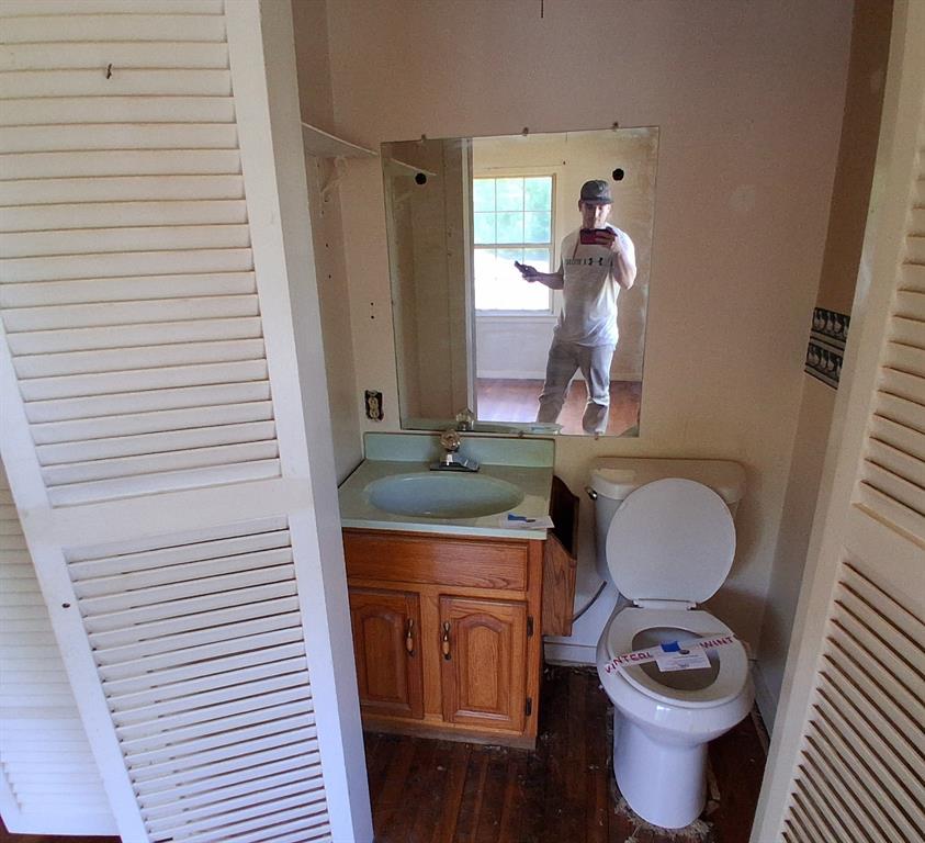 910 Success Street Gilmer, TX 75644 - Photo 17 of 20 a bathroom with a toilet a sink and mirror