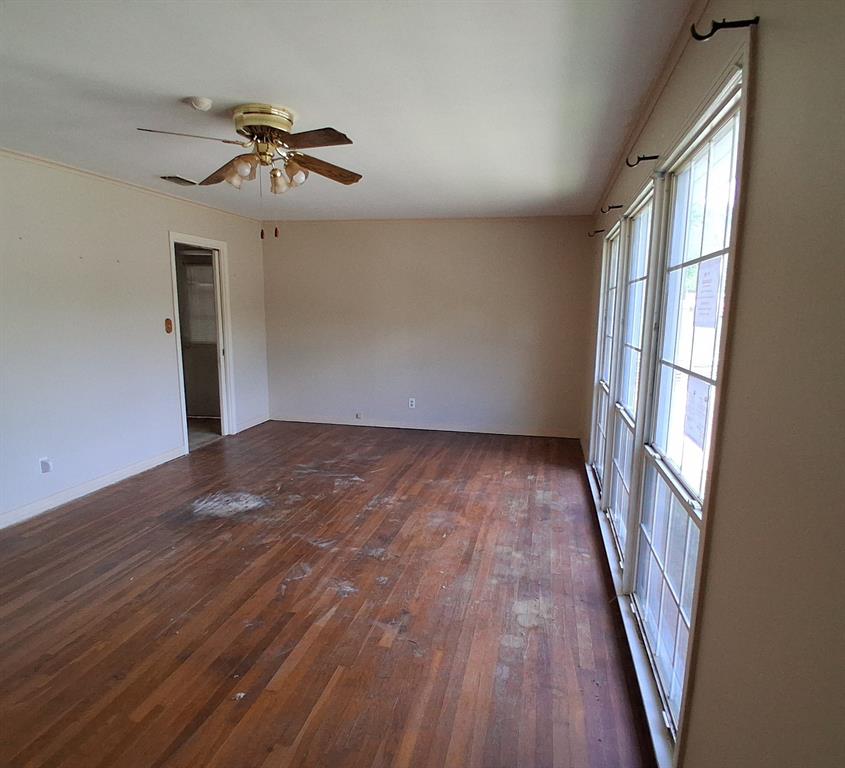 910 Success Street Gilmer, TX 75644 - Photo 3 of 20 wooden floor in an empty room with a window