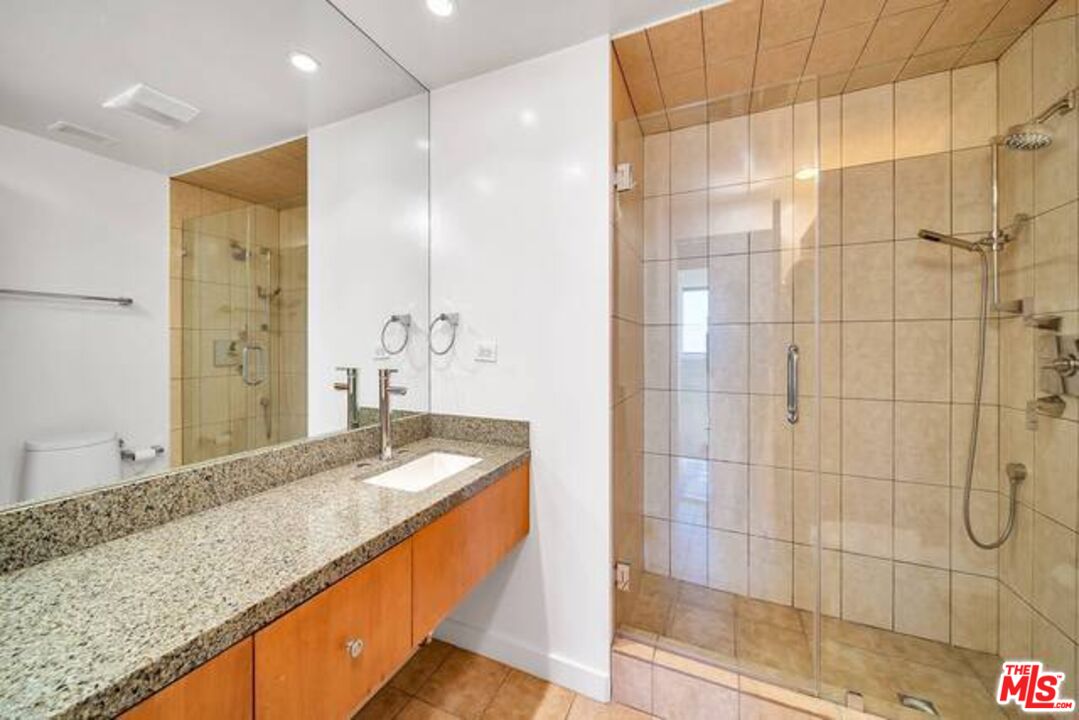 2220 Avenue Of The Stars, Unit 2004W Los Angeles, CA 90067 - Photo 22 of 25 a bathroom with a granite countertop sink and a shower