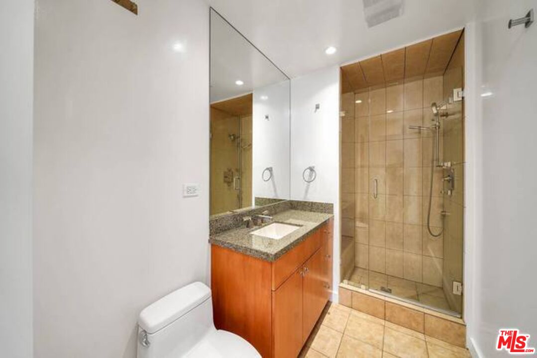 2220 Avenue Of The Stars, Unit 2004W Los Angeles, CA 90067 - Photo 23 of 25 a bathroom with a granite countertop sink a toilet and shower