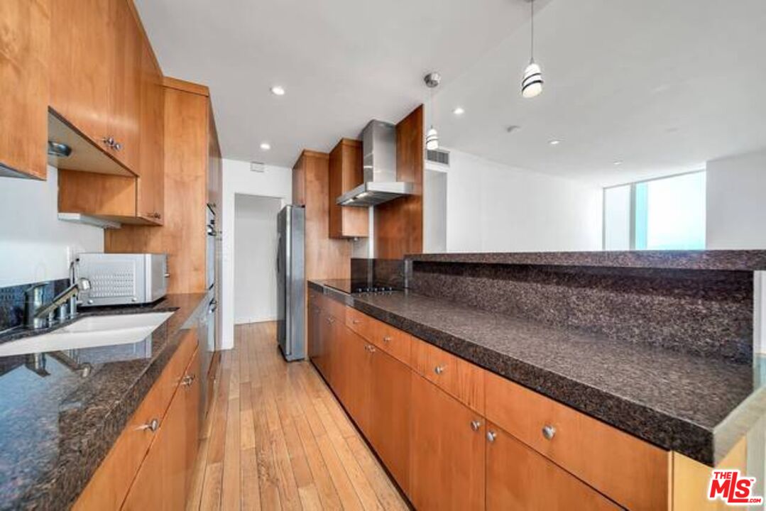2220 Avenue Of The Stars, Unit 2004W Los Angeles, CA 90067 - Photo 9 of 25 a large kitchen with stainless steel appliances granite countertop a lot of counter space and a sink