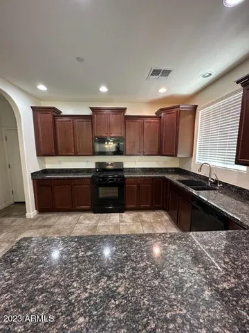 a large kitchen with wooden cabinets and a stove top oven
