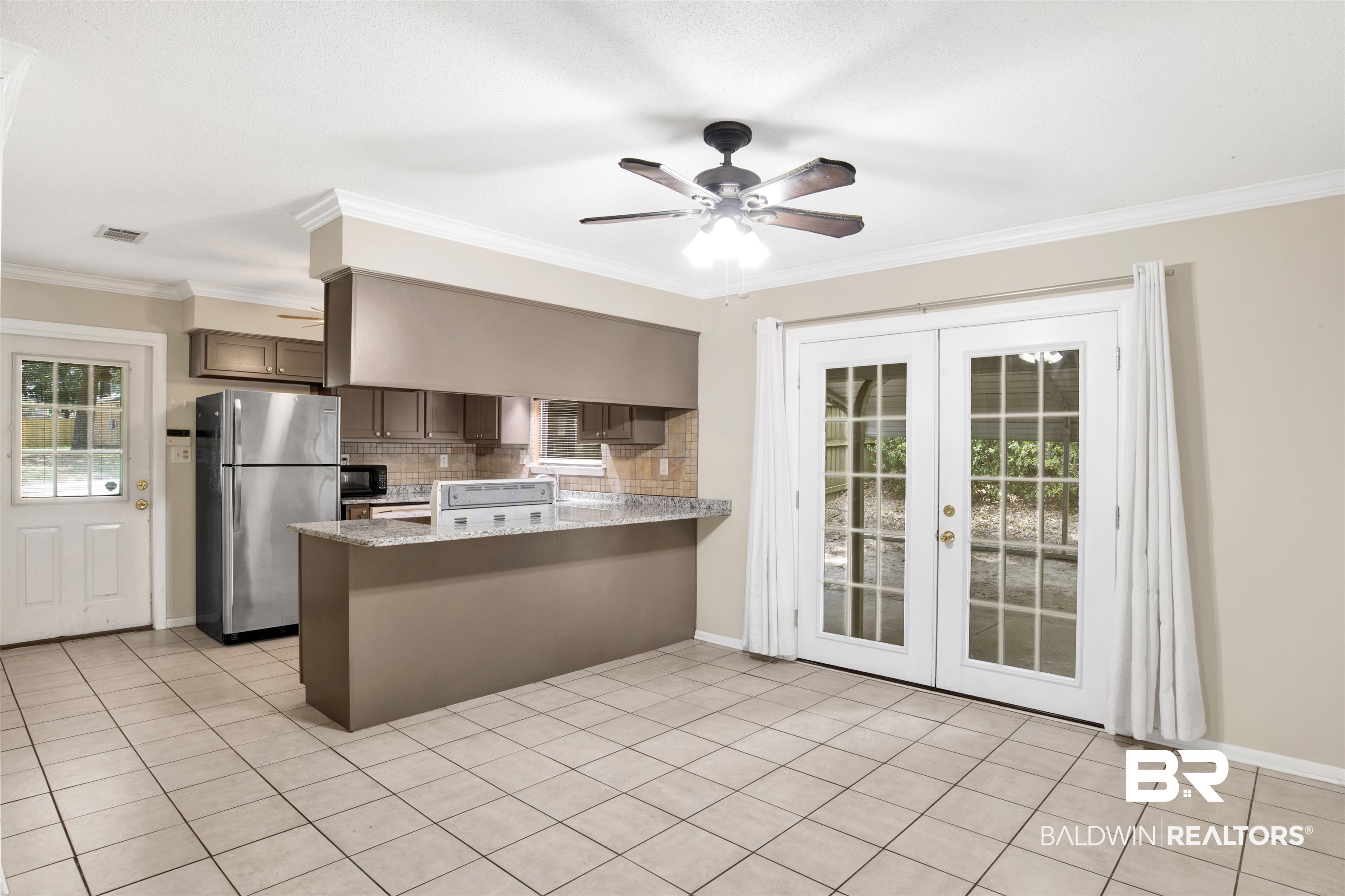 3560 Creekway Road Mobile, AL 36619 - Photo 9 of 24 Kitchen with decorative backsplash, ceiling fan, kitchen peninsula, stainless steel refrigerator, and ornamental molding