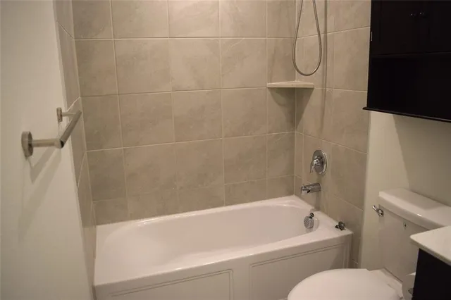 a bathroom with a bath tub a toilet and a shower