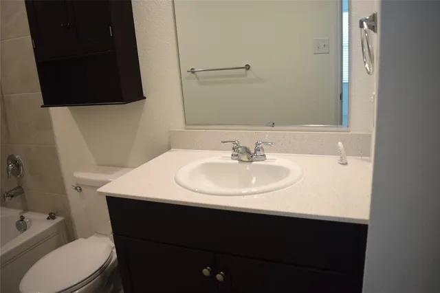 a sink sitting under a bathroom mirror