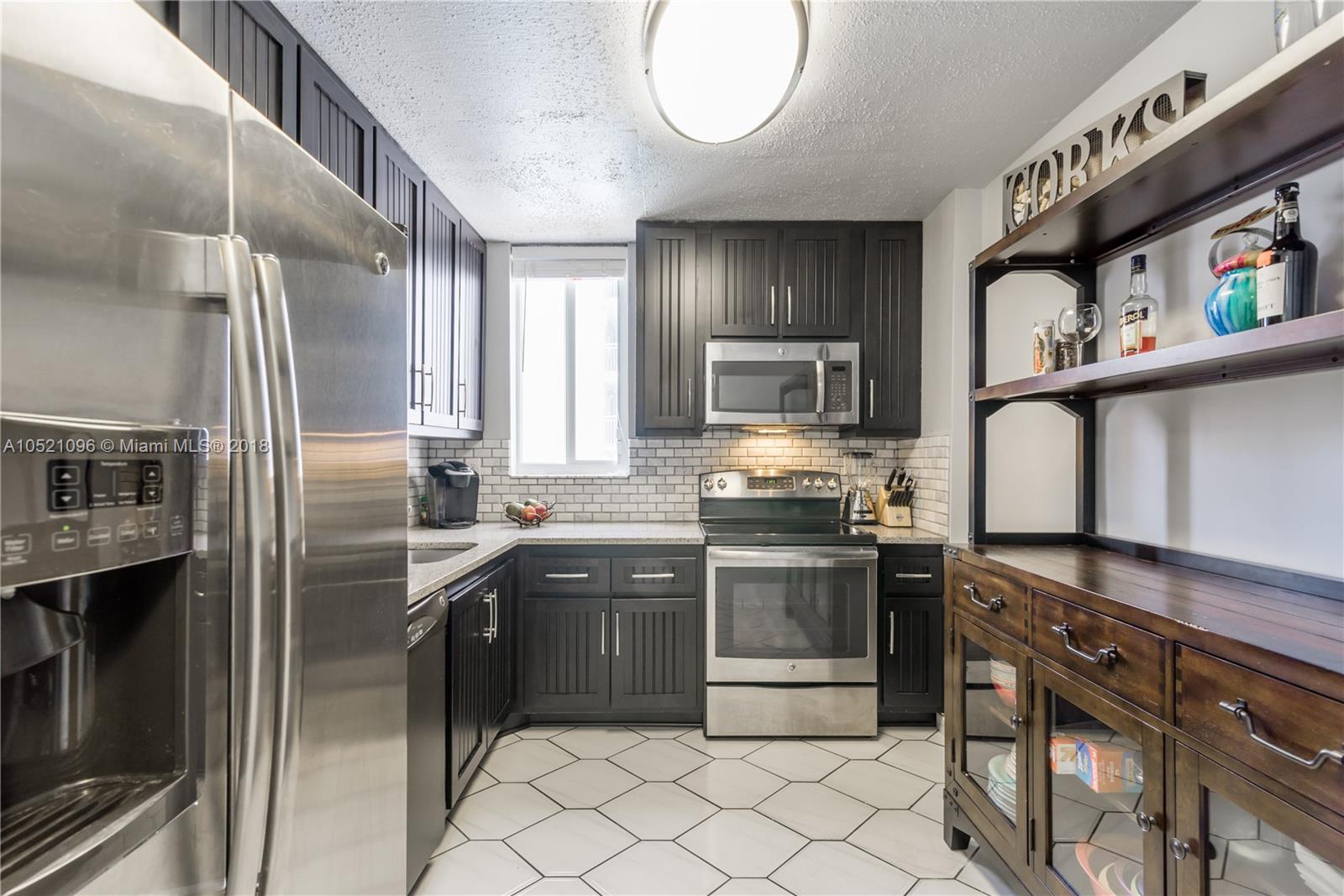 1665 Bay Road, Unit 425 Miami Beach, FL 33139 - Photo 5 of 15 a kitchen with stainless steel appliances granite countertop a sink a stove a refrigerator and island
