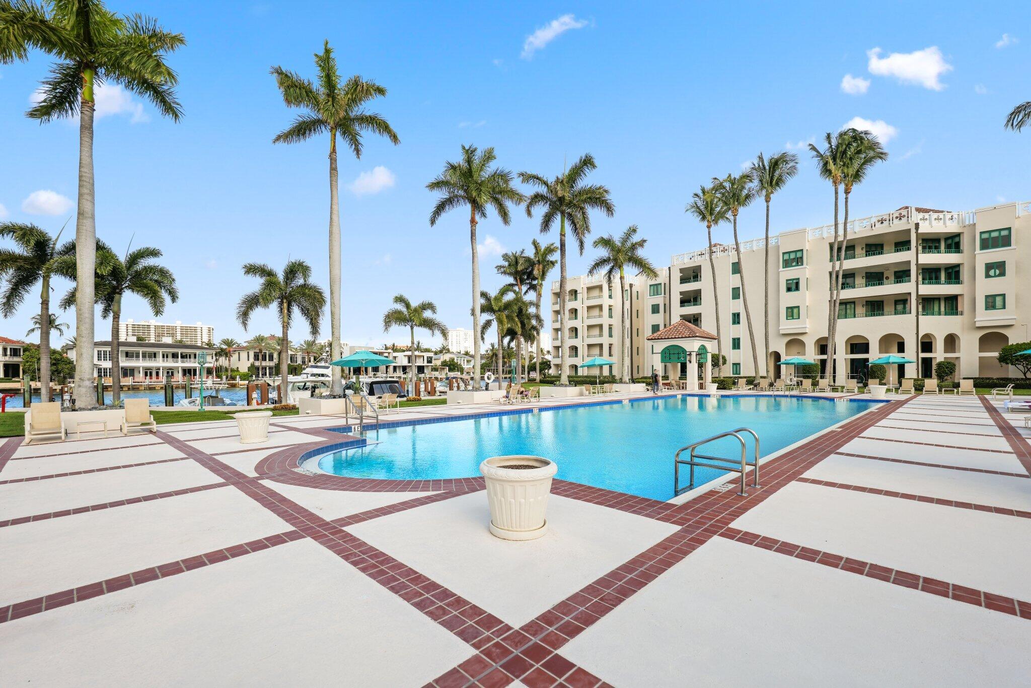 100 Southeast 5th Avenue, Unit 106 Boca Raton, FL 33432 - Photo 53 of 81 a view of a swimming pool with a lawn chairs and palm tree